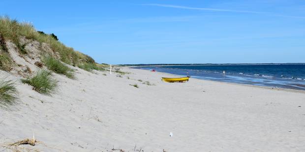 Feiner Ostseestrand mit Dünen und einem gelben Boot auf dem Sand