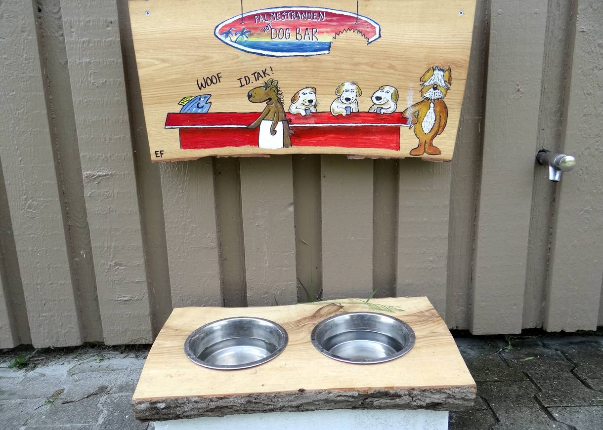 Wassernäpfe mit einem handgemalten Hinweisschild für Hunde