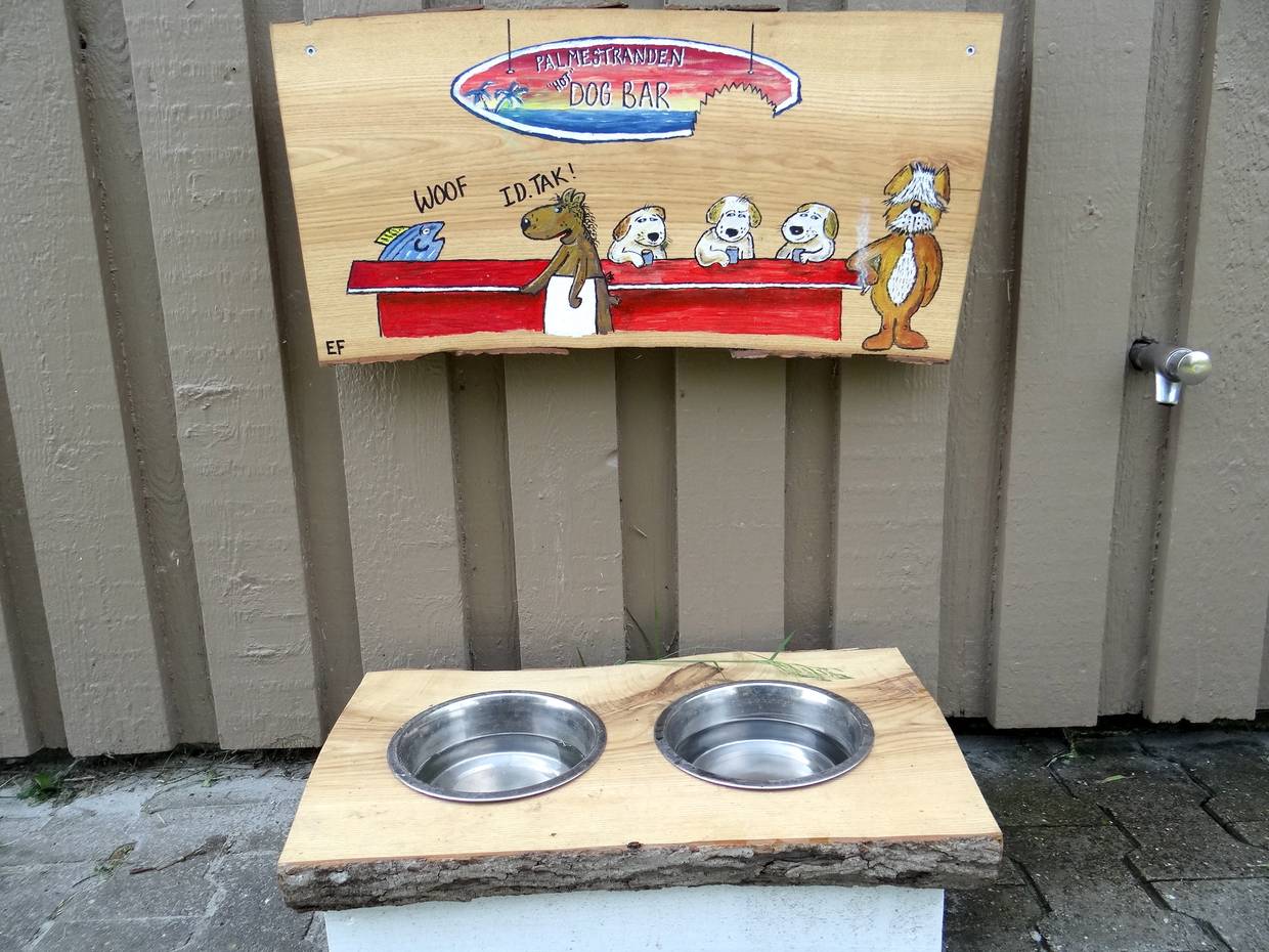 Wassernäpfe mit einem handgemalten Hinweisschild für Hunde