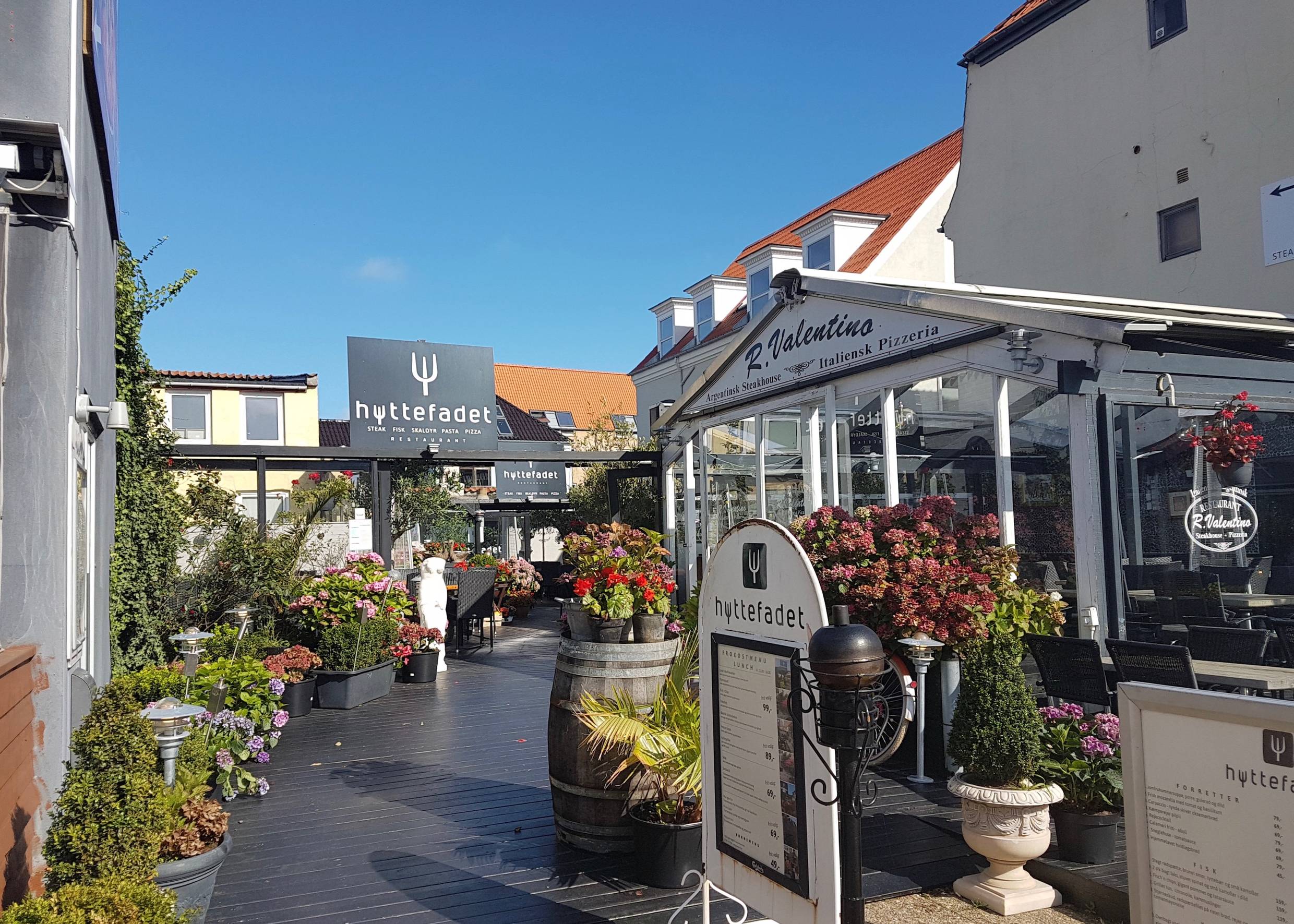 Mit sehr vielen Blumenkübeln geschmückte Restaurantterrasse