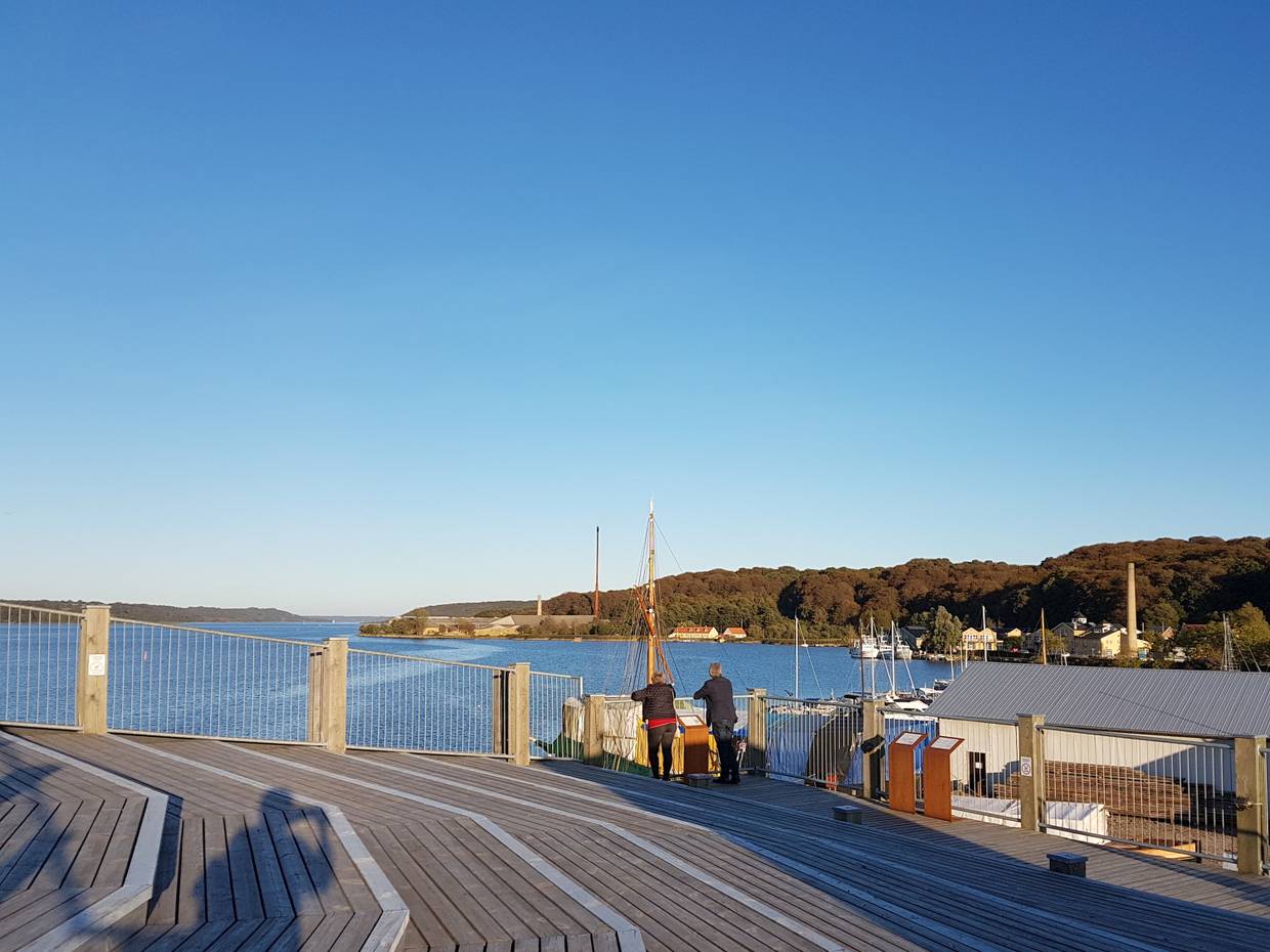 Ein Paar genießt die Aussicht von einer Holzterrasse über dem Fjord