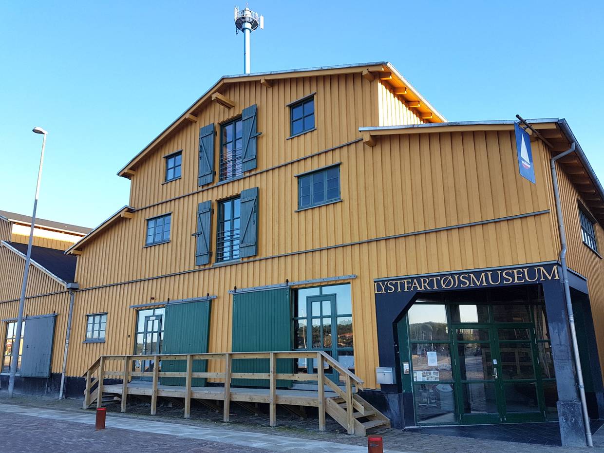 Gelbes Holzhaus mit grünen Fensterläden