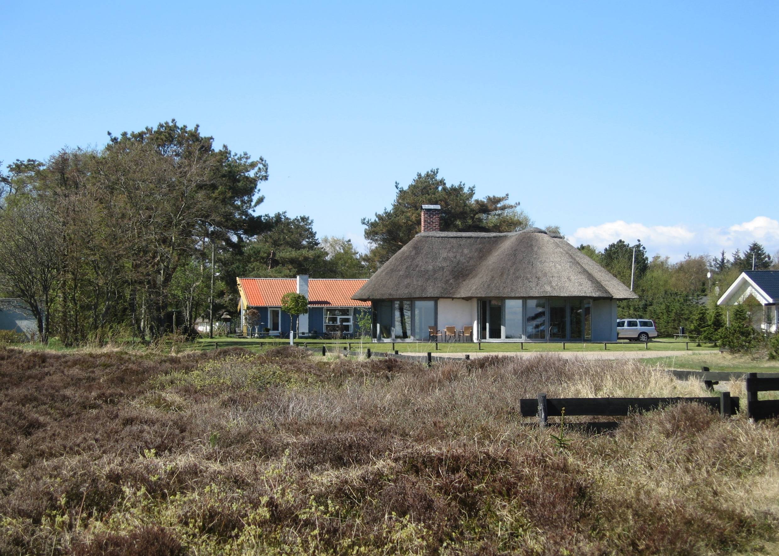 Reetdachhaus, davor trockene Heide