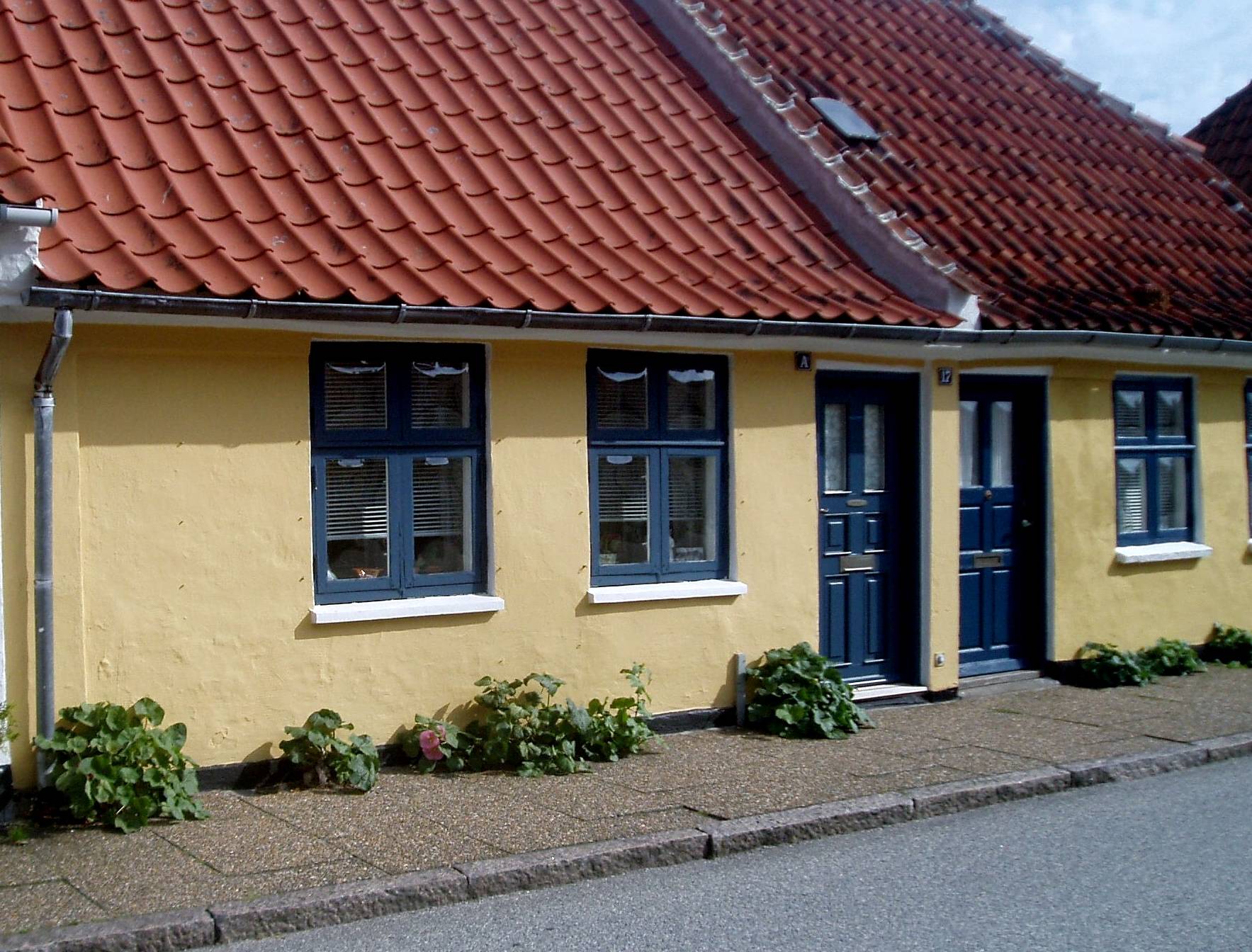 Gelbe Häuser mit blauen Fenstern und Rüren
