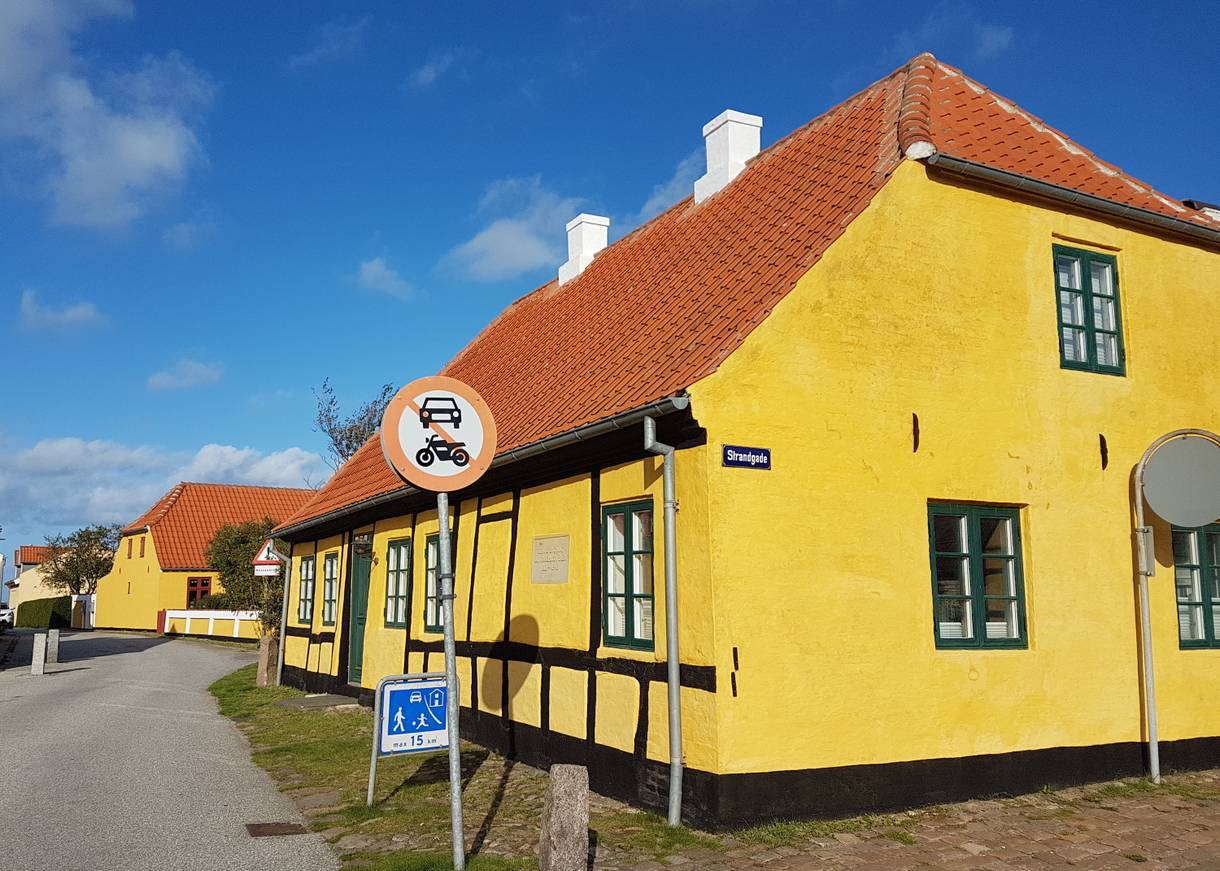 Gelbes Fachwerkhaus mit grünen Fensterrahmen, davor ein Schild Fußgängerzone