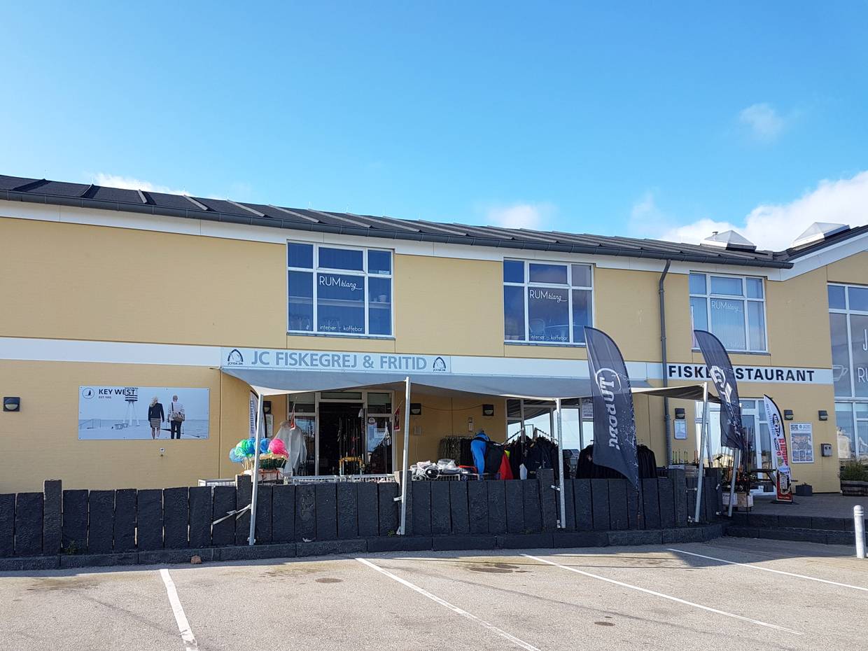 Geschäft mit Angelbedarf und Kleidung, darüber ein Restaurant