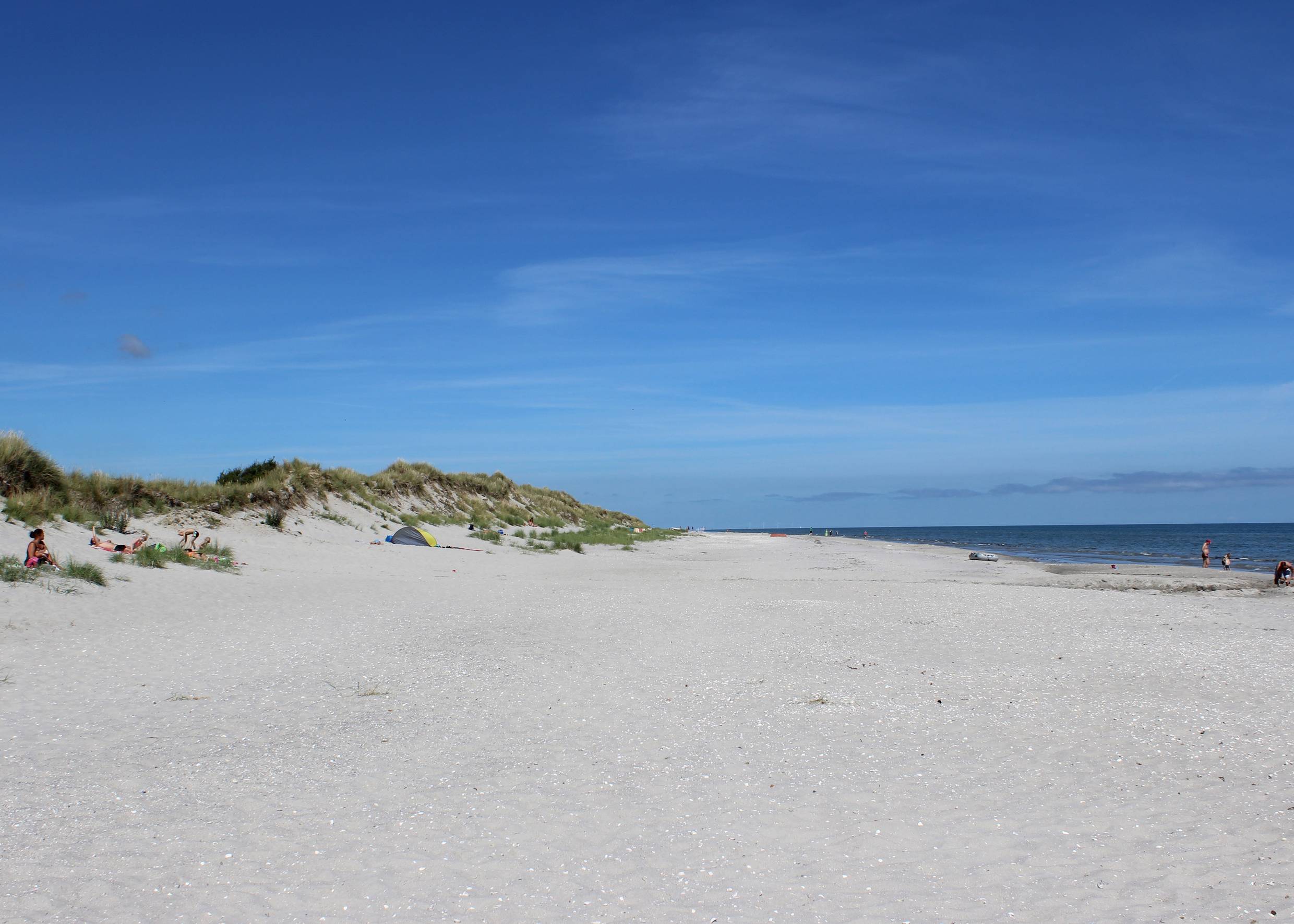Weißer Sandstrand an der Ostsee, flache Dünen mit einigen Badegästen