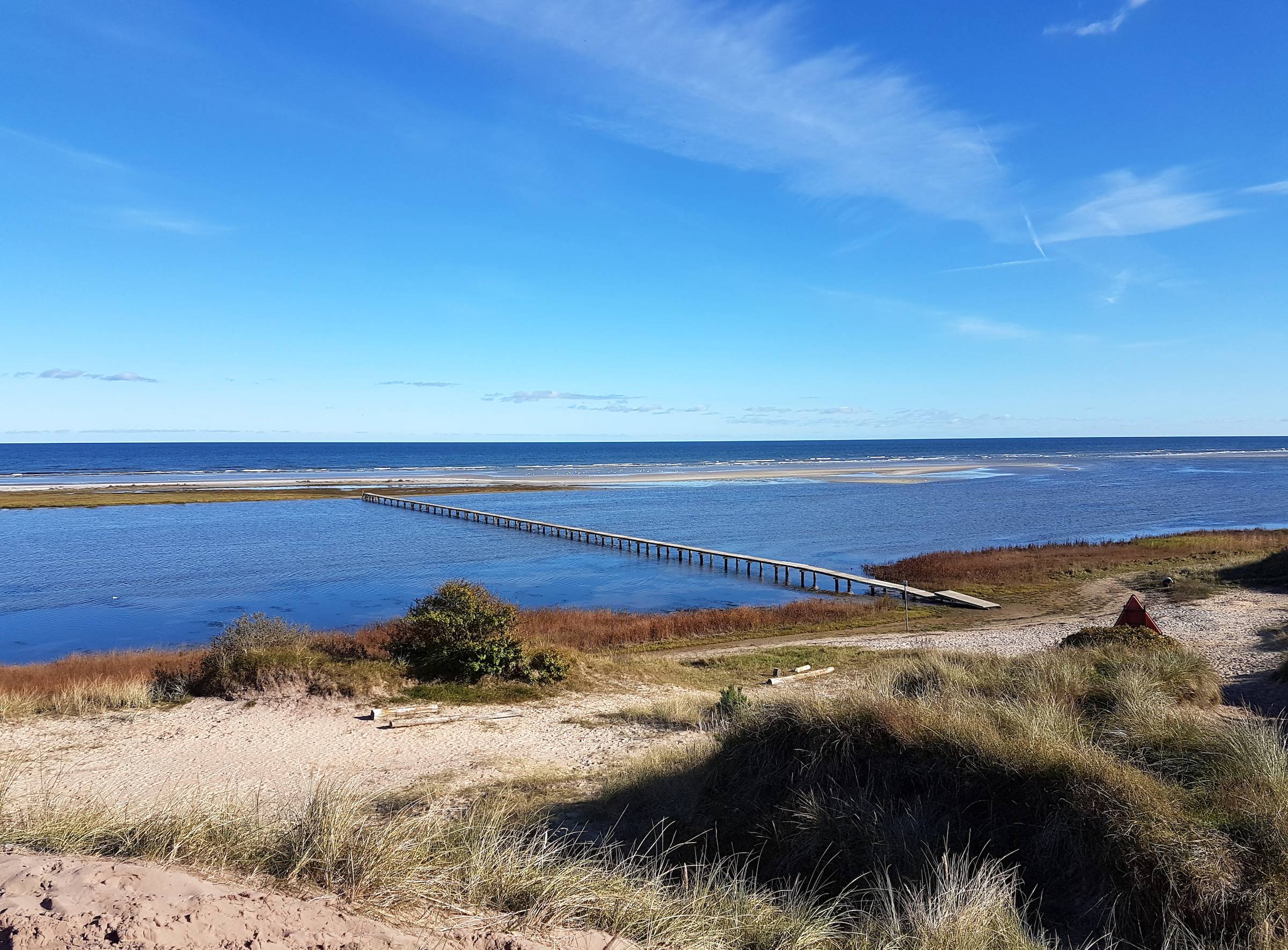 Sehr langer Badesteg über eine Lagune zur Sandbank