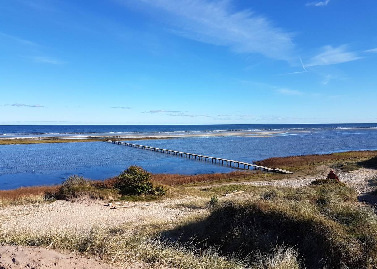 Sehr langer Badesteg über eine Lagune zur Sandbank