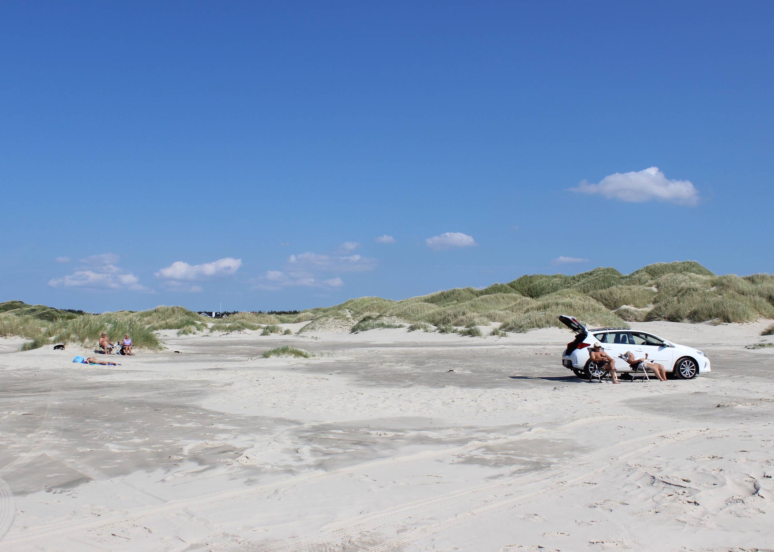 Verscheiden hohe Dünen auf dem Strand, dazwischen Badegäste