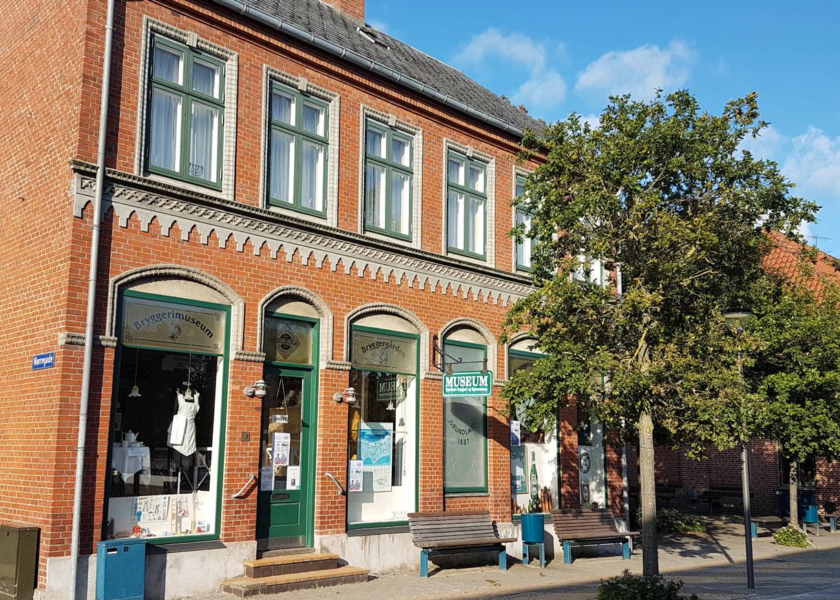 Backsteinhaus mit dem Stadtmuseum, davür ein Laubbaum