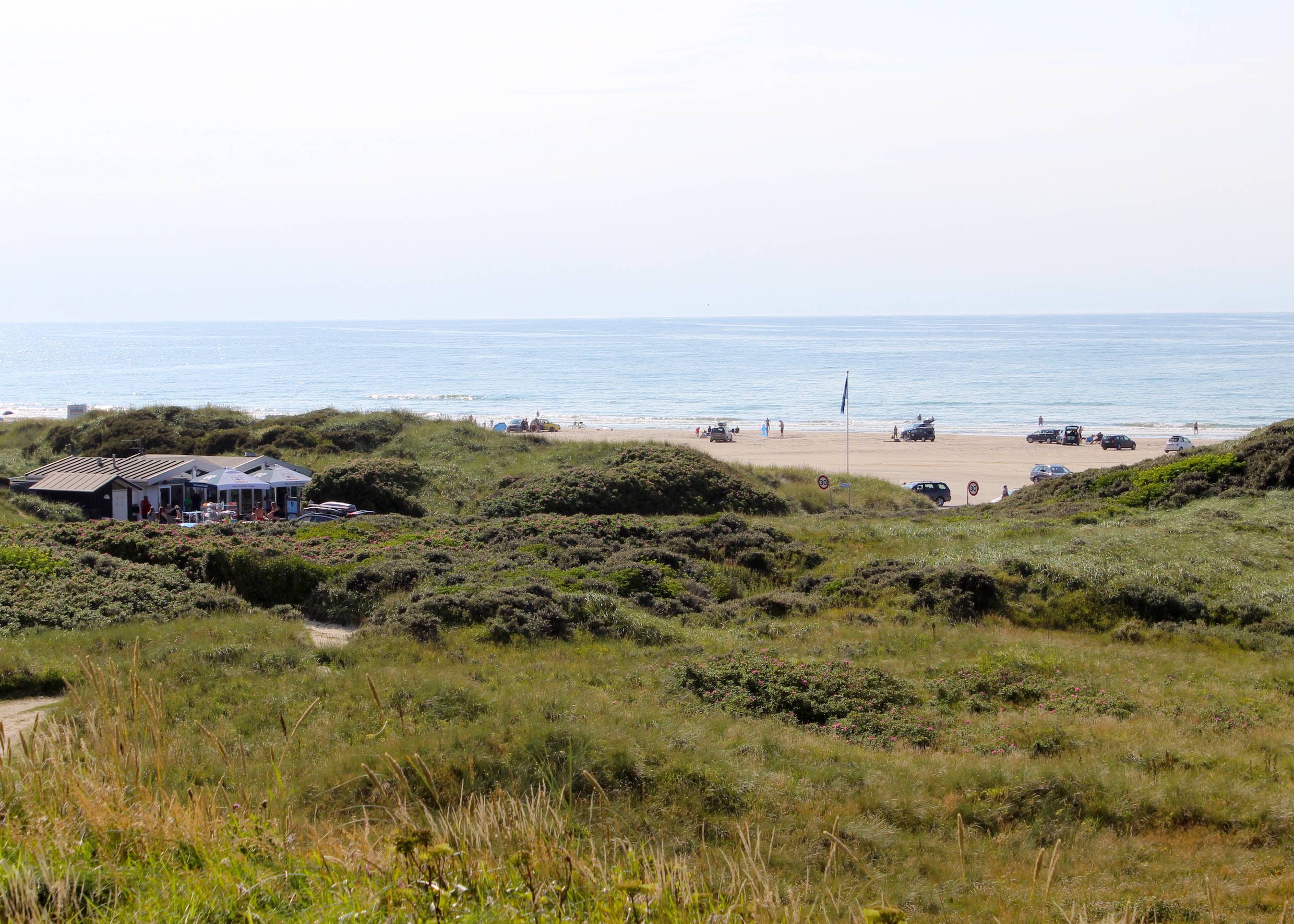 Blick von den Dünen auf den Strand und einen Strandkiosk