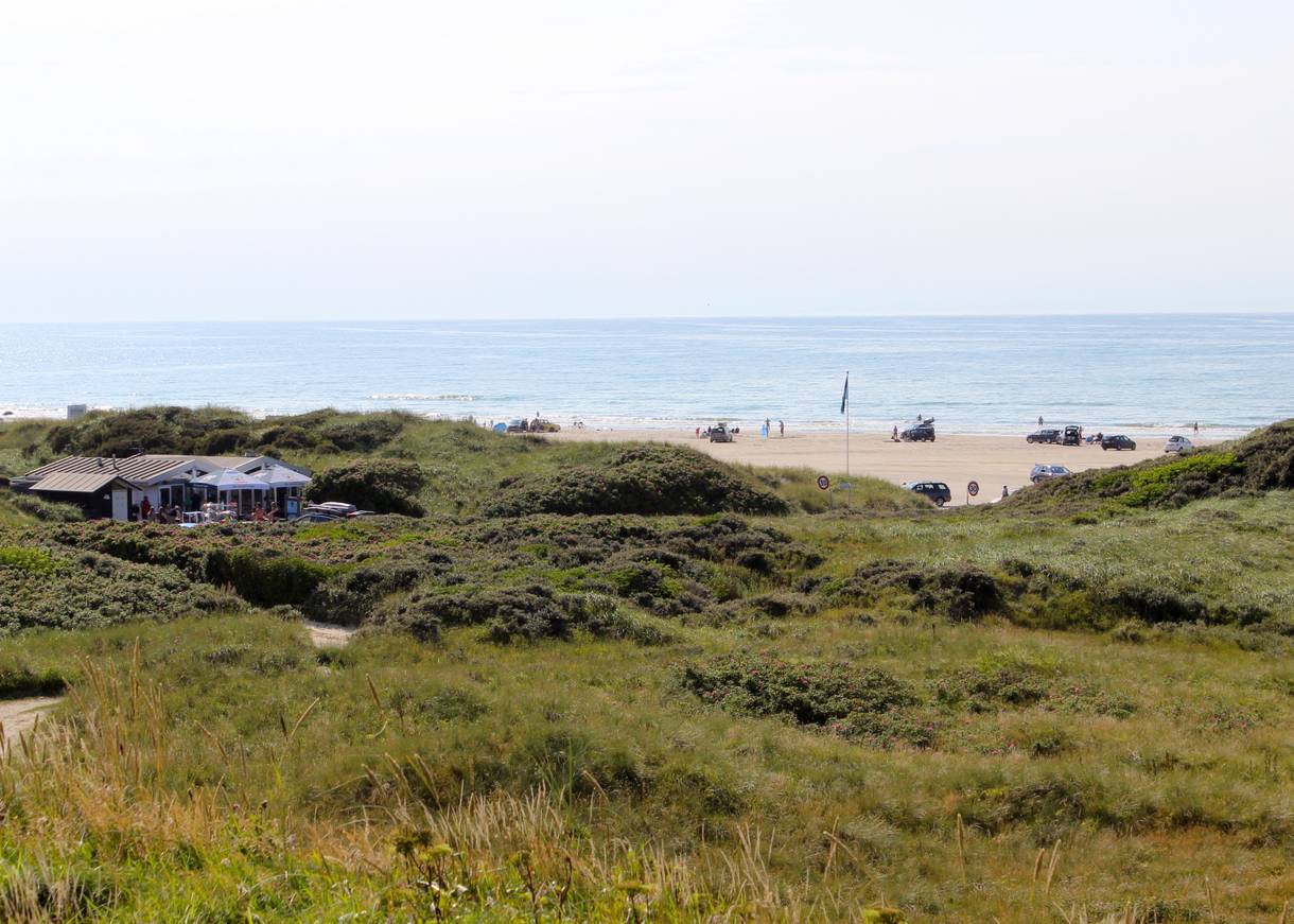 Blick von den Dünen auf den Strand und einen Strandkiosk