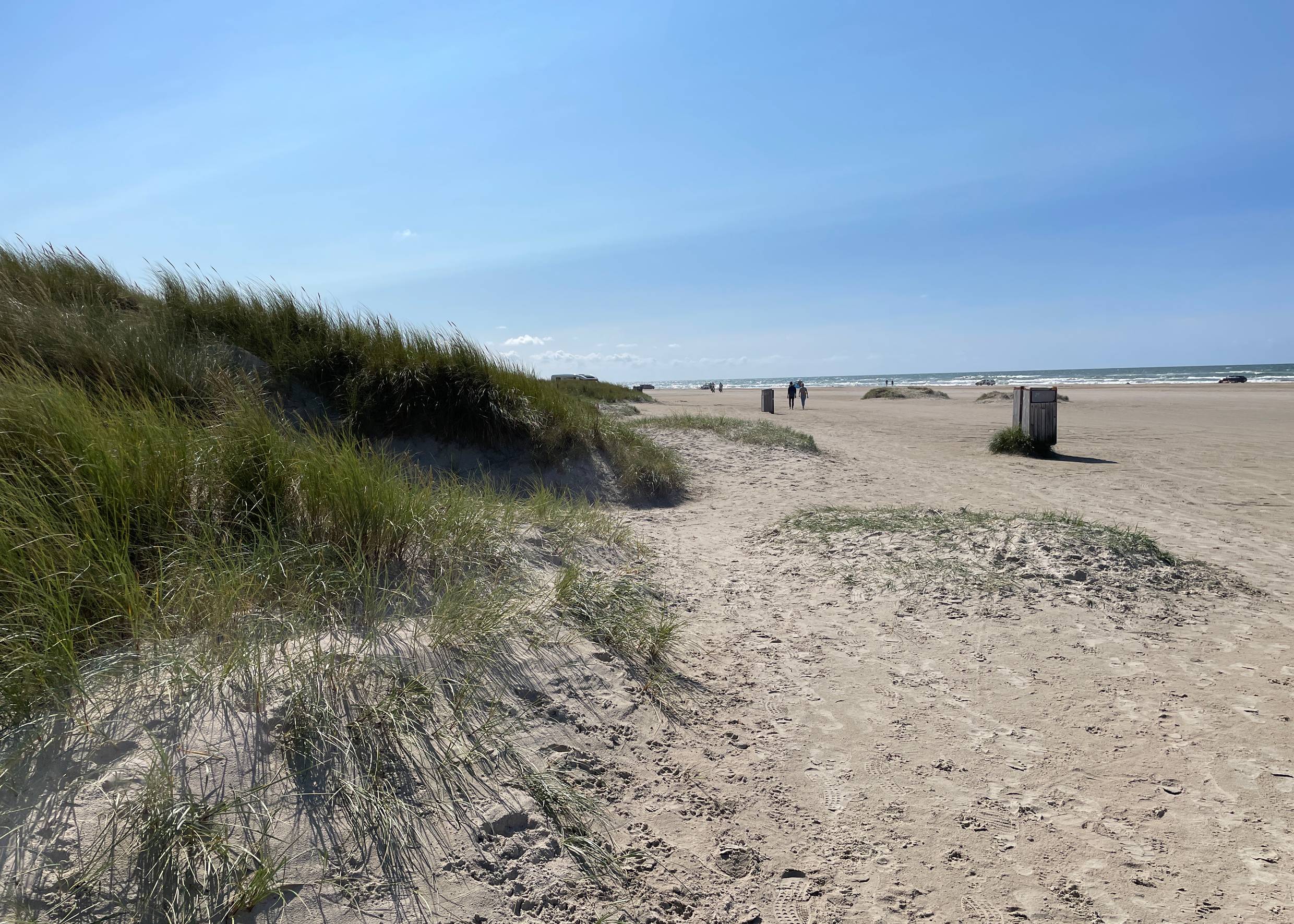 Sehr breiter, flacher Strand mit Autos in der Ferne