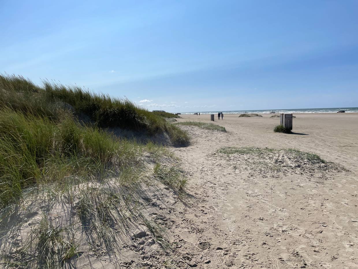 Sehr breiter, flacher Strand mit Autos in der Ferne