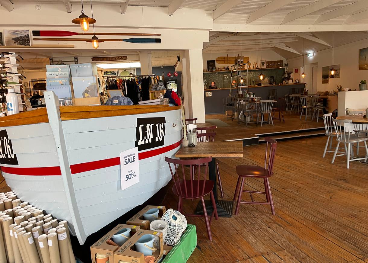 Hellblauer Schiffsrumpf in einem Conceptstore mit Ausschank