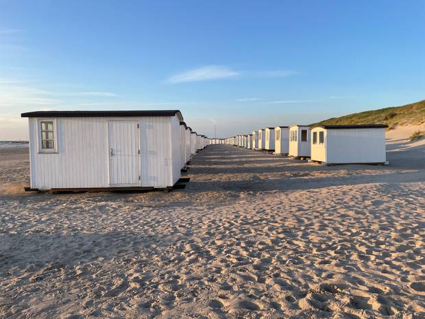 Zwei Reihen mit weißen Badenhäusern am Strand