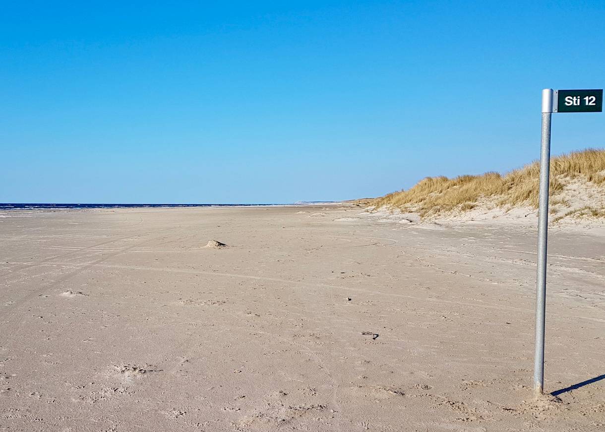 Straßenschild mit einer 12 auf dem Strand
