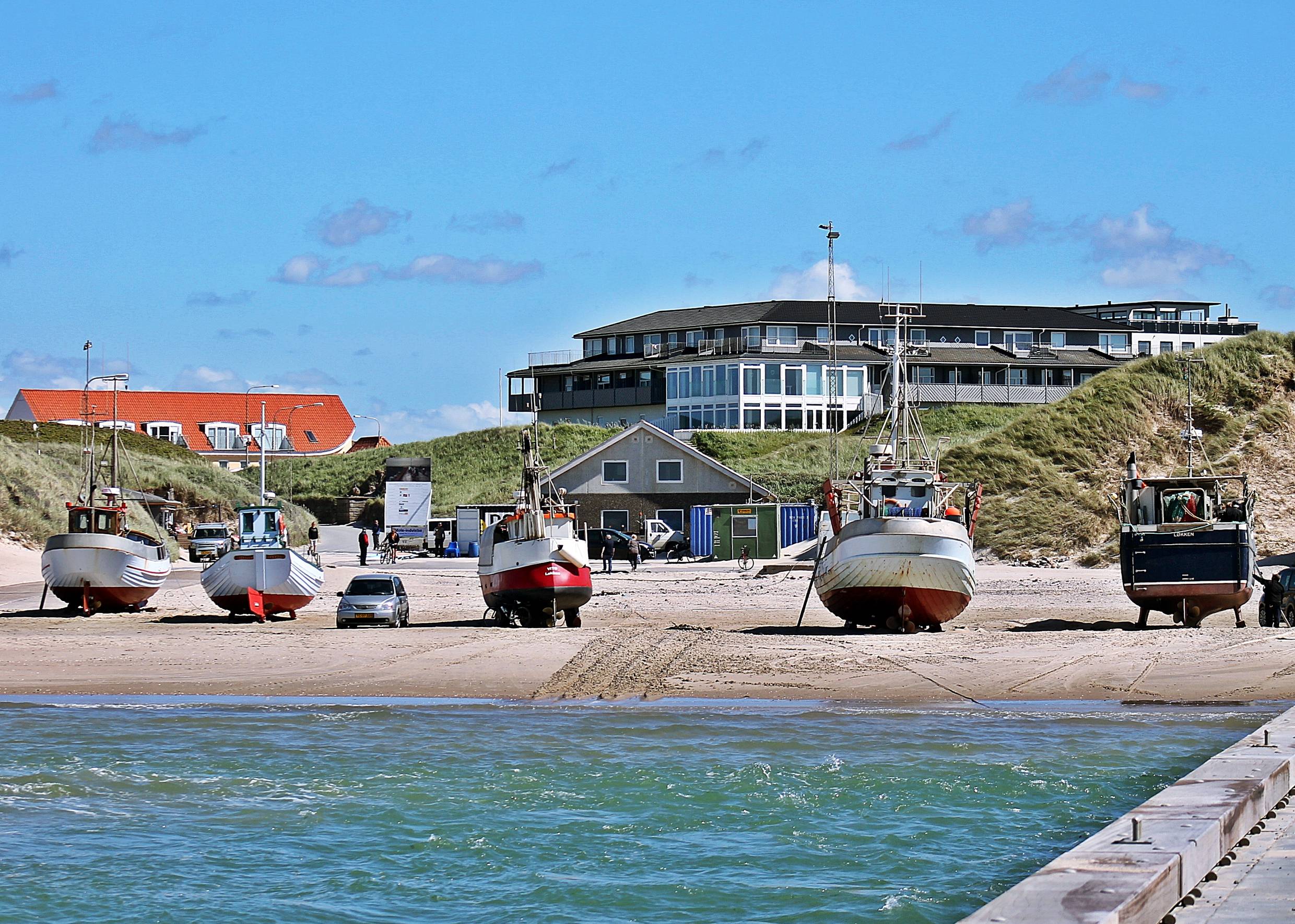 Fischerboote auf dem Strand, dahinter Dünen