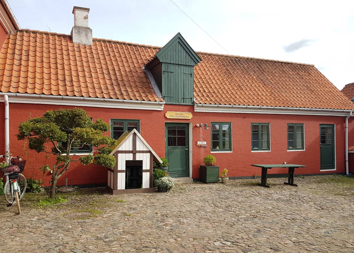 Rotes Haus mit grünen Tüeren und Fenstern