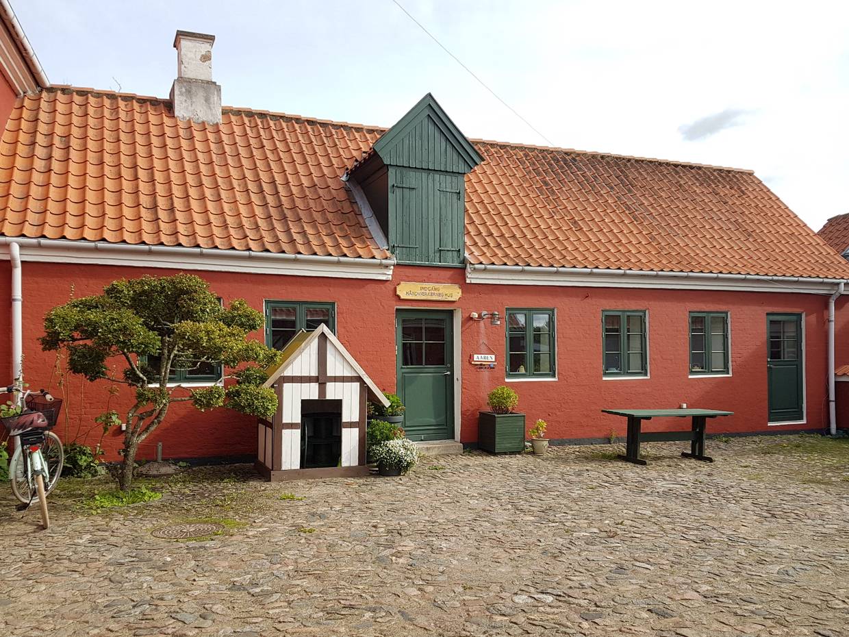 Rotes Haus mit grünen Tüeren und Fenstern
