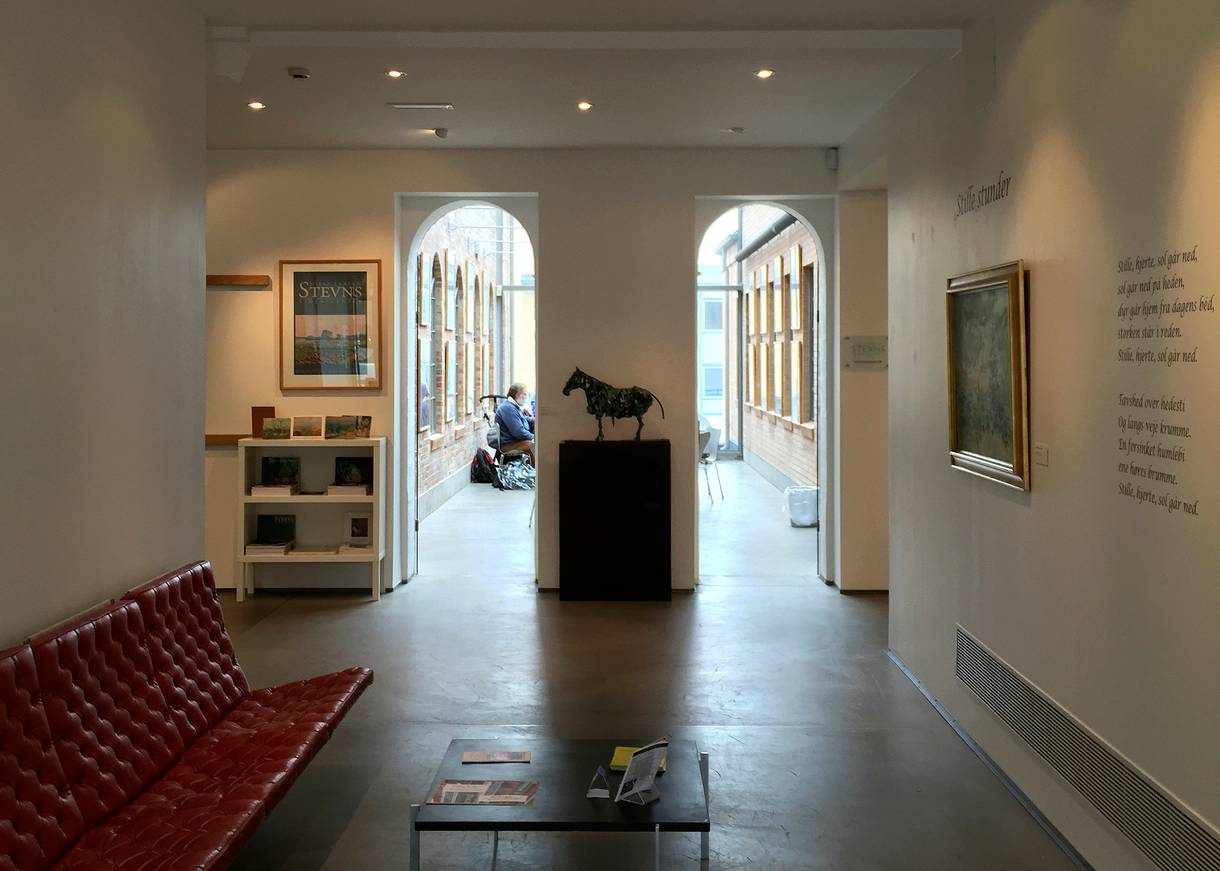 Eingang im Museum, ein roter Ledersitz und eine Skuptur von einem Pferd 