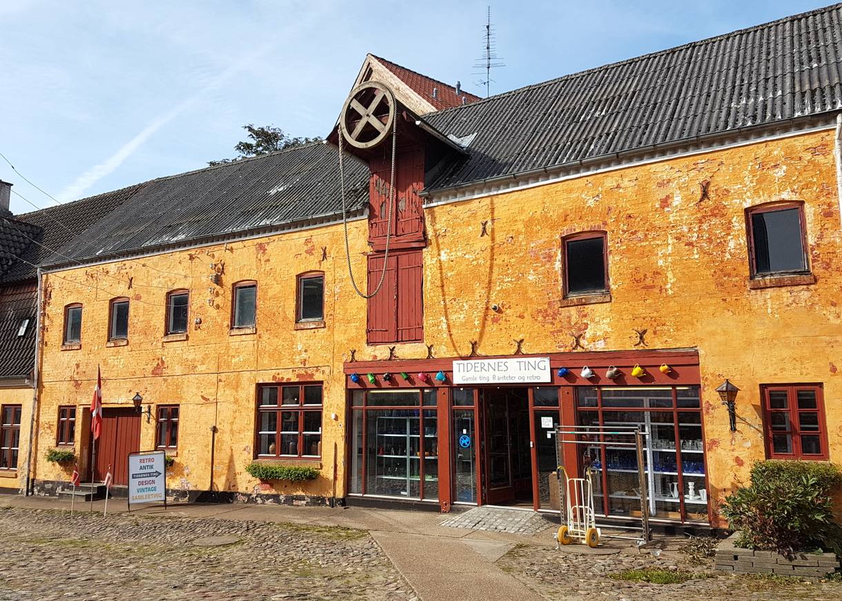 Gelbe Front eines historischer Kaufmannshof mit einem Trödelladen