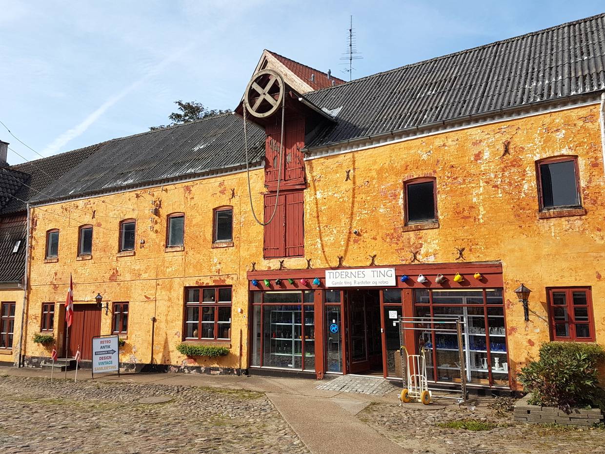 Gelbe Front eines historischer Kaufmannshof mit einem Trödelladen