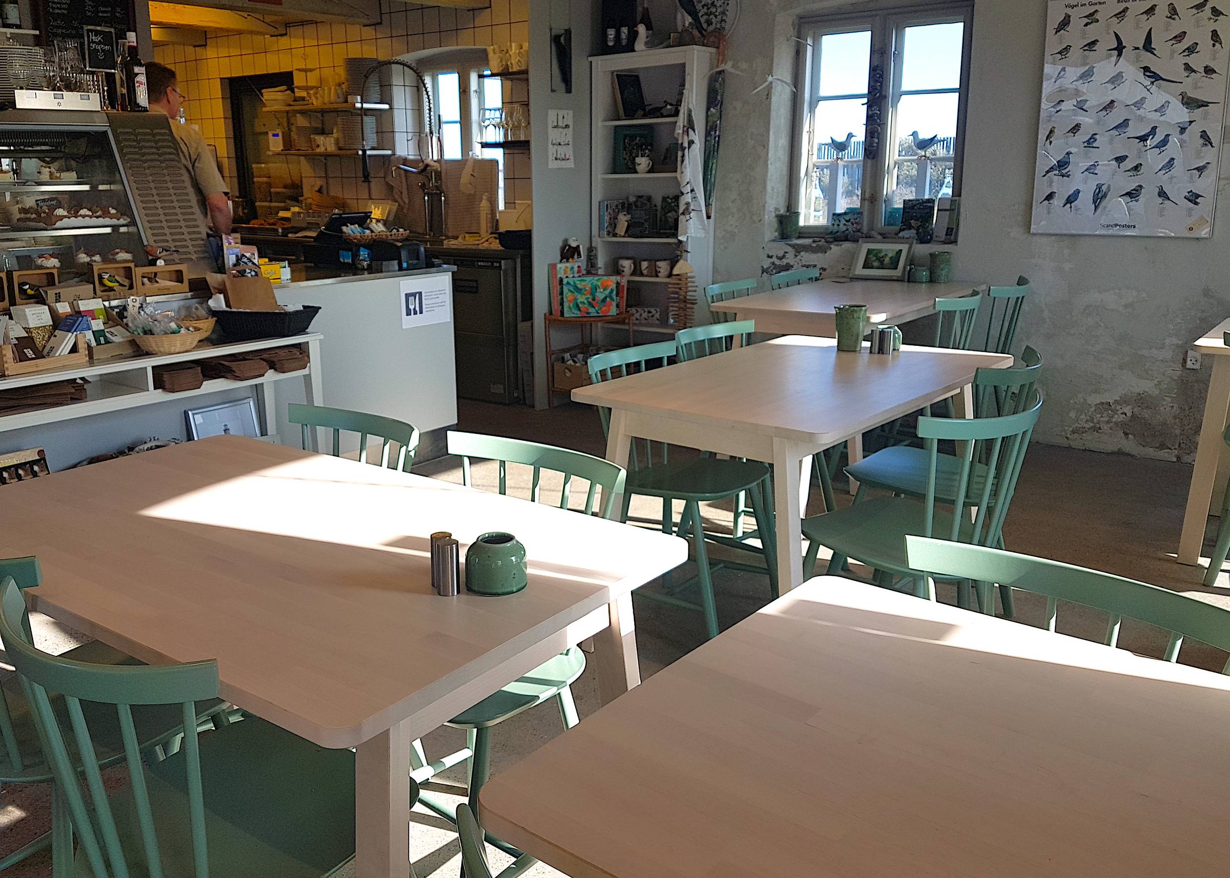 Theke und Tische in einem kleine Cafe, viel Deko mit Vogelmotiven