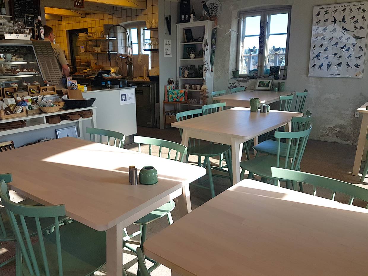 Theke und Tische in einem kleine Cafe, viel Deko mit Vogelmotiven