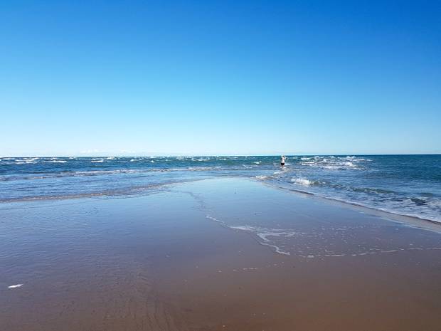 Zwei Meere treffen sich, im Wasser ein Mann mit Fernglas