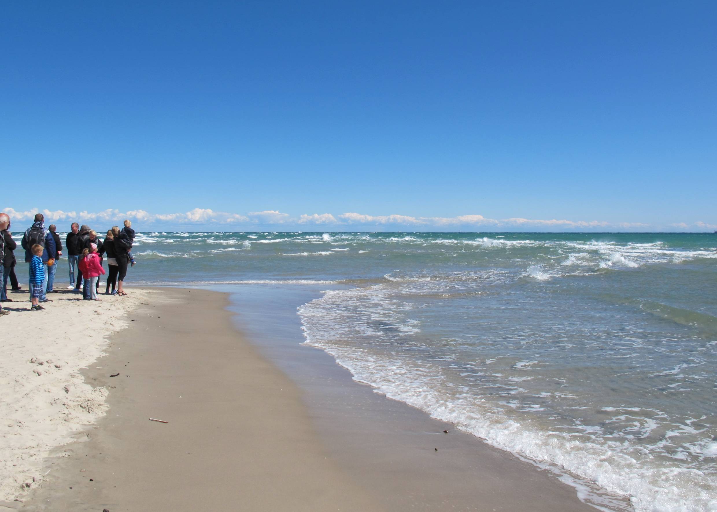 Strandbesucher schauen sich das Zusammentreffen der Meer an