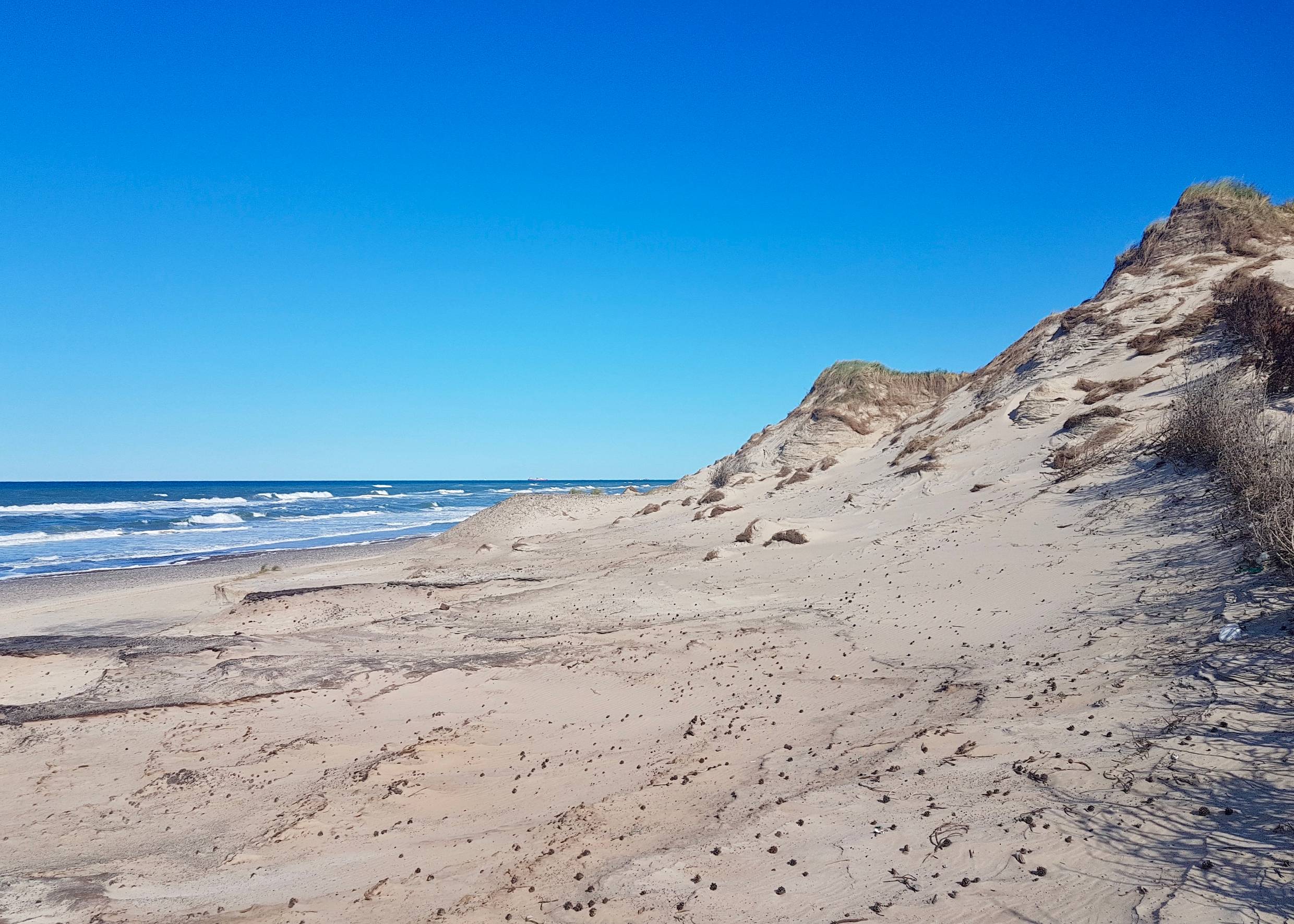 Von Wind und Wasser zerfurchte Dünen am Meer