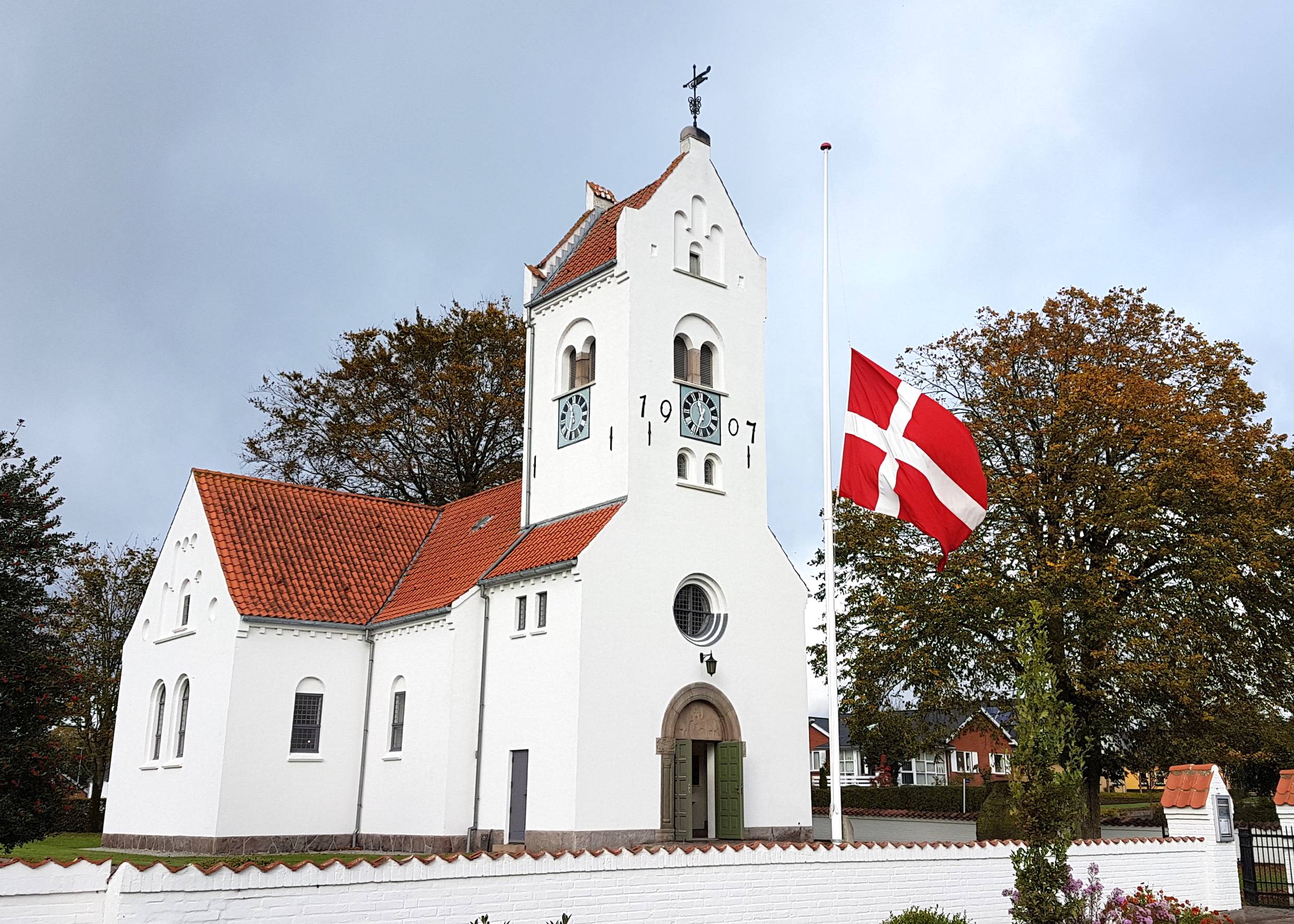 Weiße Kirche, davor eine dänischen Fahne im Wind