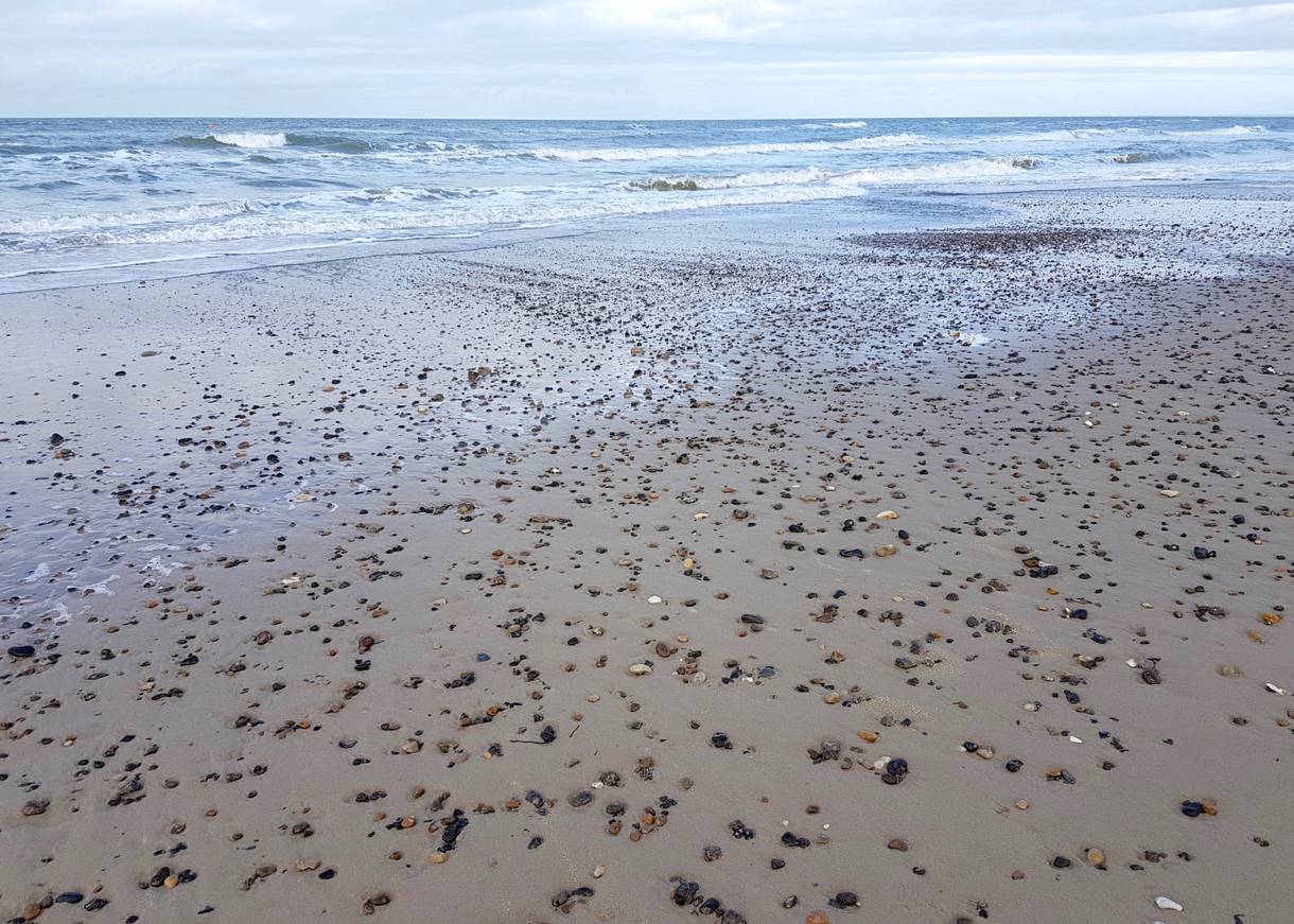 Sandstrand mit vielen kleinen Steinen