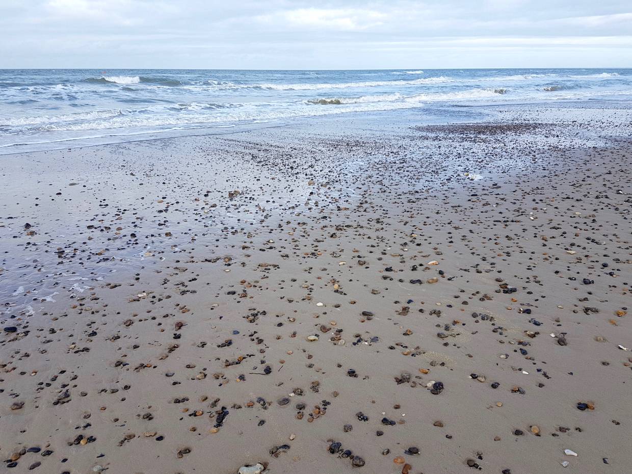 Sandstrand mit vielen kleinen Steinen