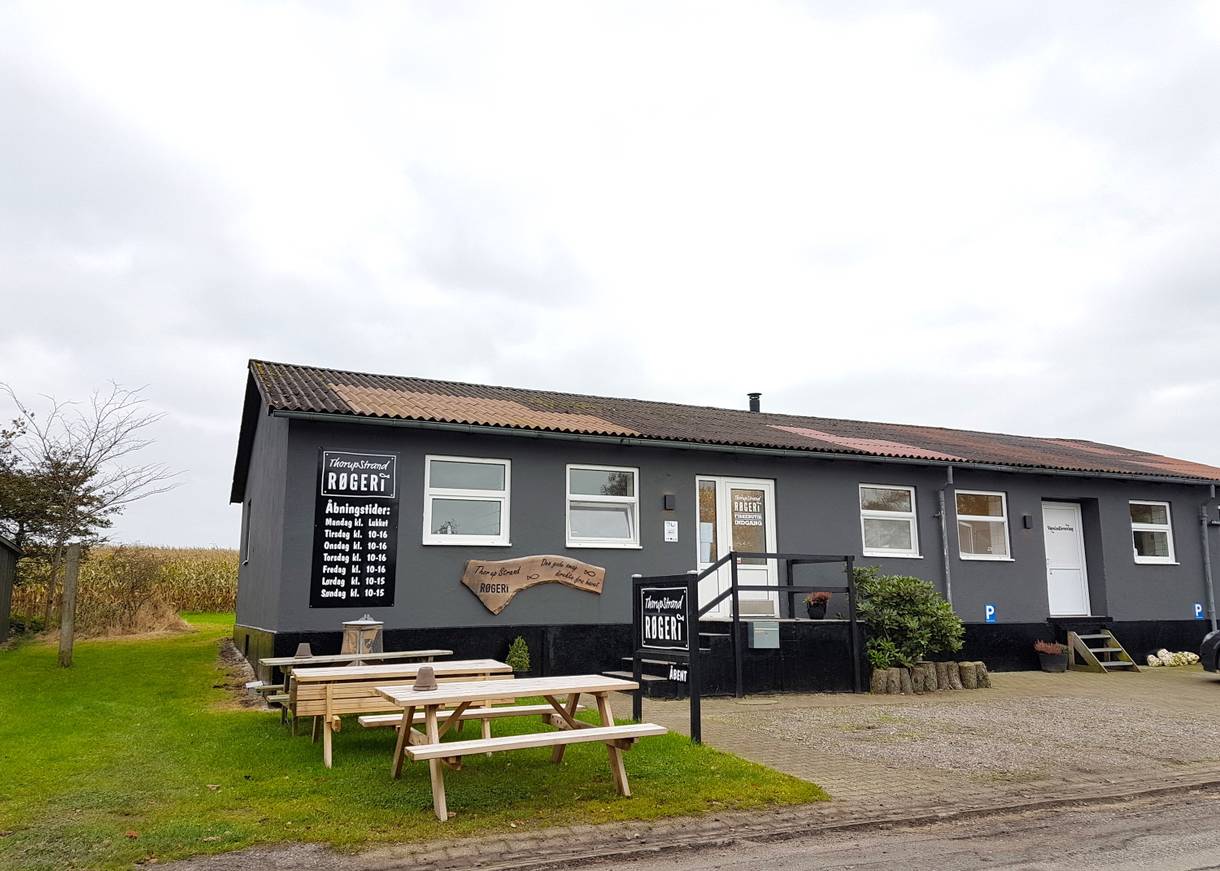 Schwarzes flaches Holzhaus mit einer Fischräucherei