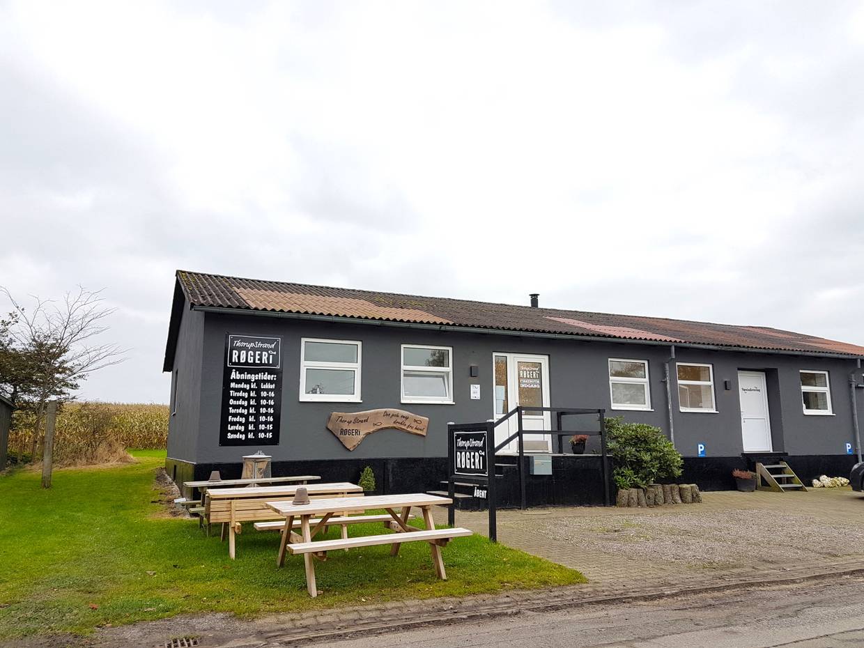 Schwarzes flaches Holzhaus mit einer Fischräucherei
