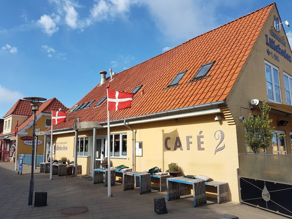 Gelbes Haus mit einem Café, Dannebrog und Holzbänke vor der Tür