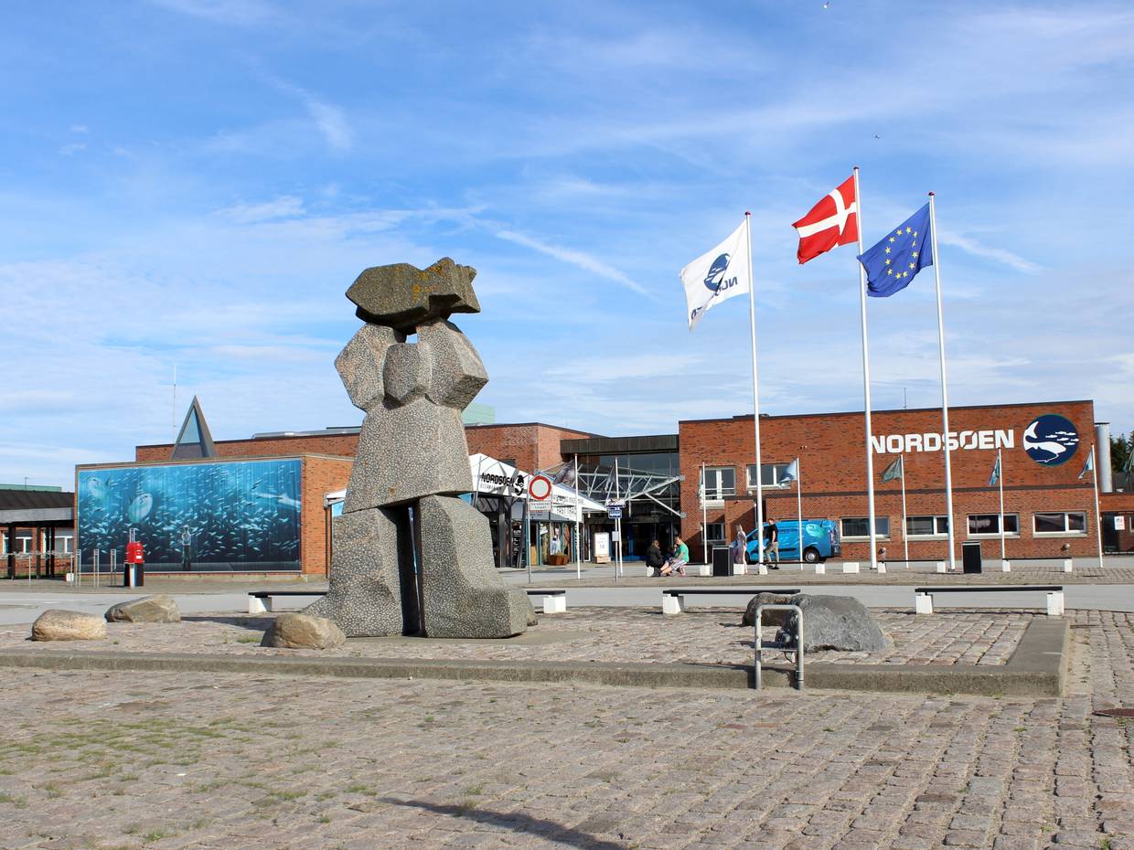 Der Vorplatz zum Aquarium mit drei Fahnenmasten und einer Steinplastik