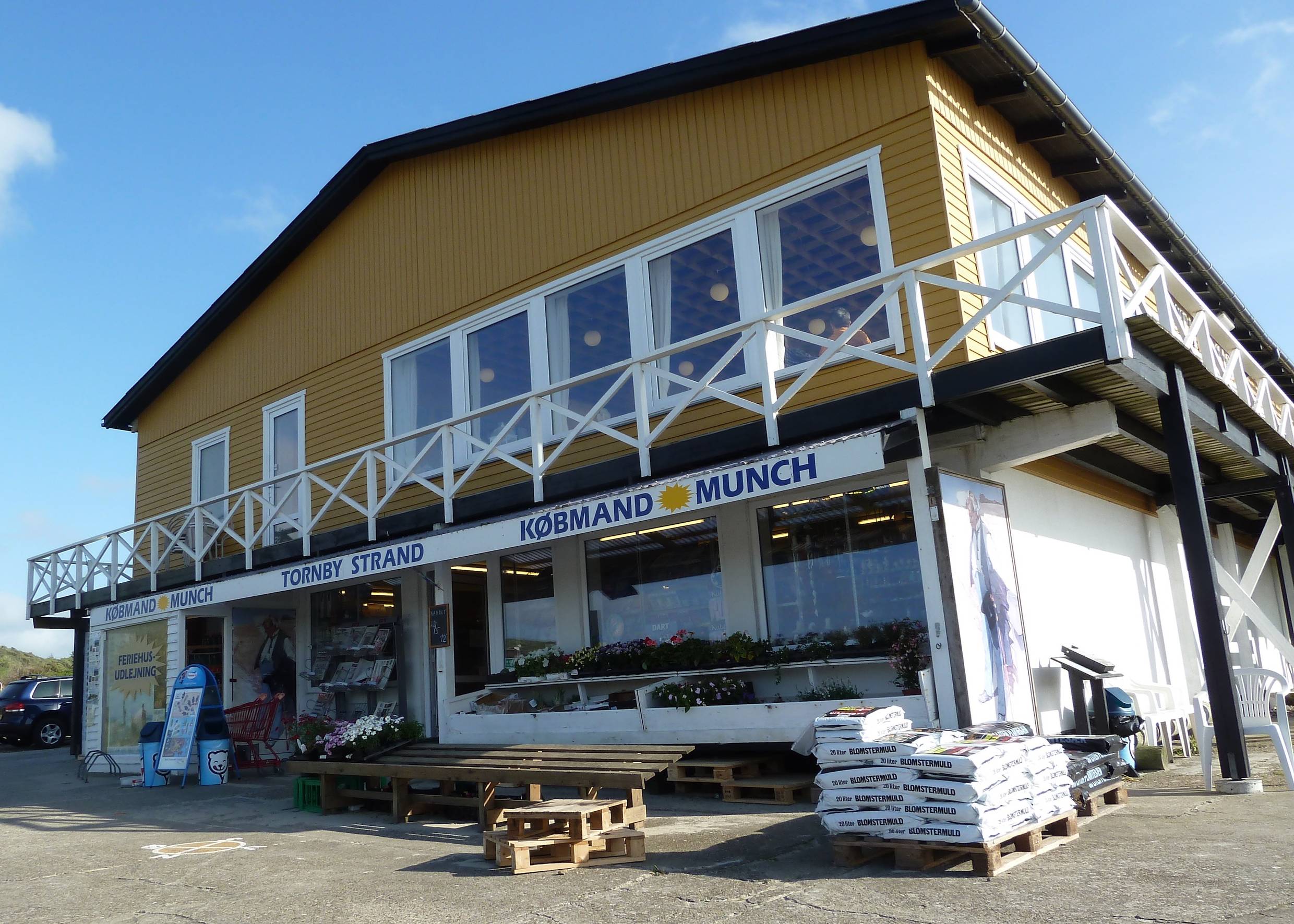 Haus mit einem Geschäft unten und im Obergeschoss ein Restaurant mit weißer Terrassenbrüstung
