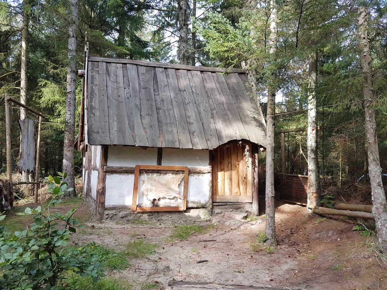 Kleines Fachwerkhaus mit Holzdach im Wald