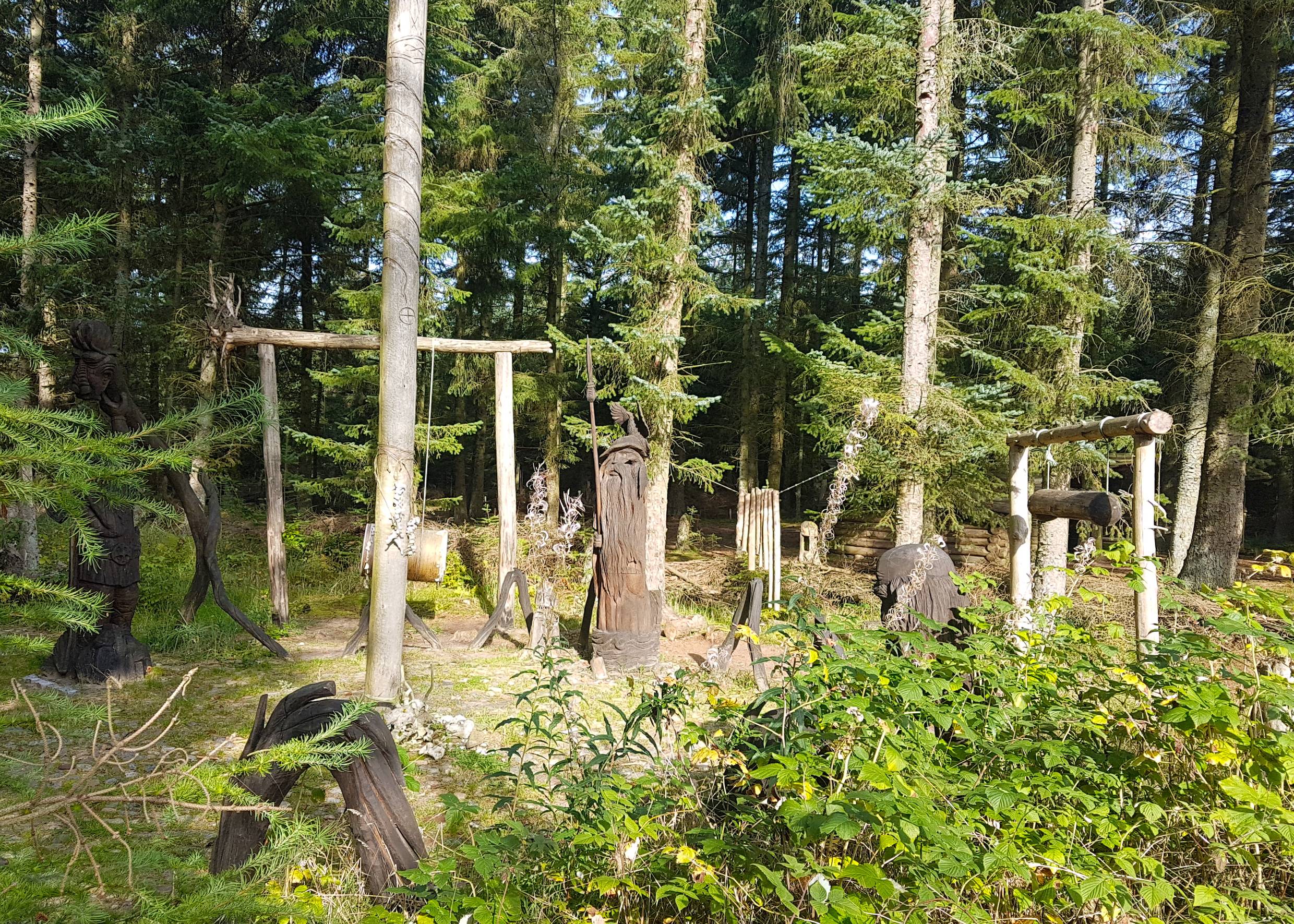 Geschnitzte Figuren in einem Waldstück