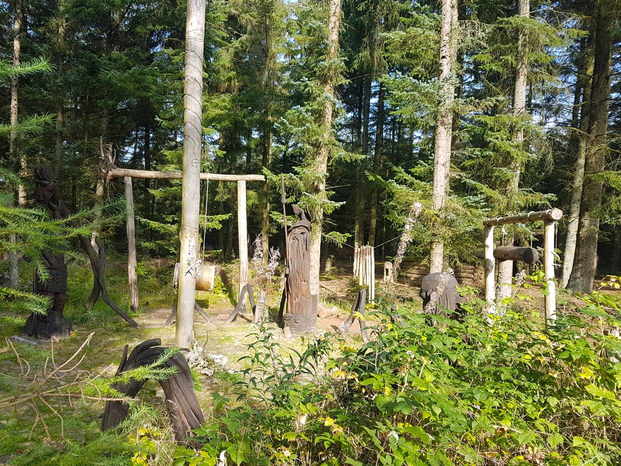 Geschnitzte Figuren in einem Waldstück