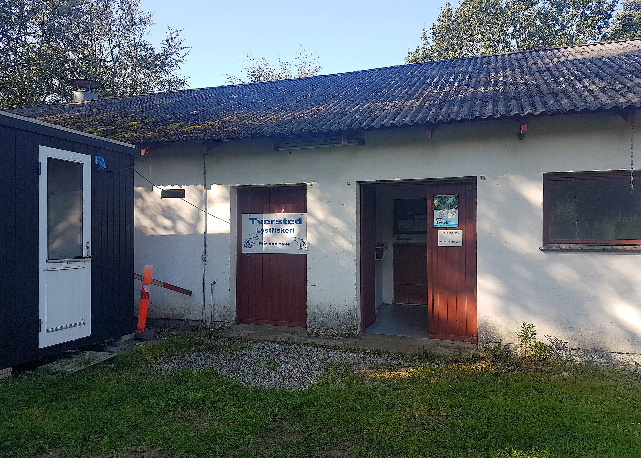 Weißer Schuppen mit Schild Tversted Fiskeri