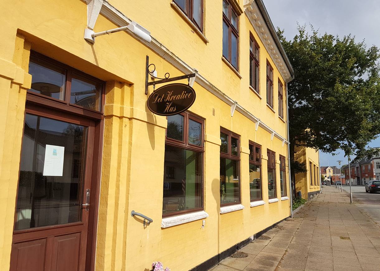 Gelbes Haus an der Straße mit kleinen Schaufenstern