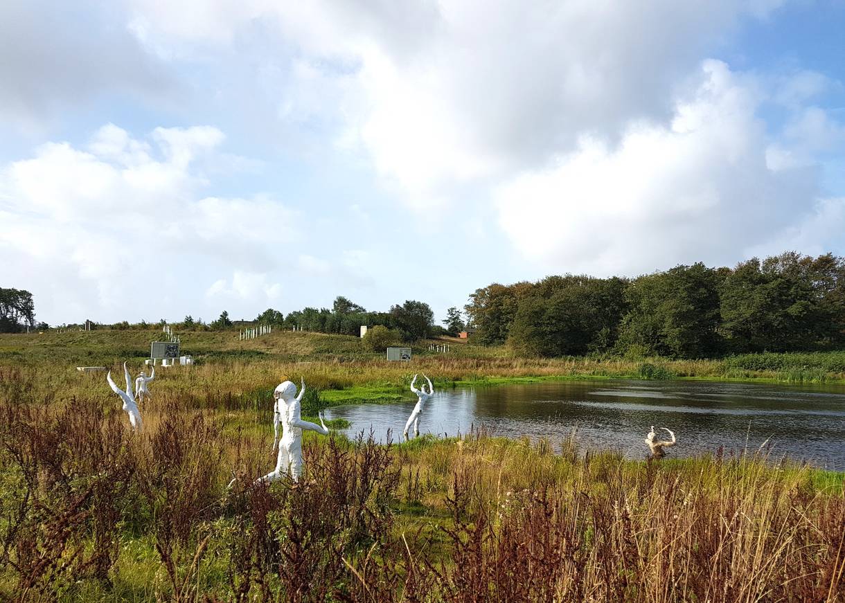 Weiße Figuren an einem kleinen Teich