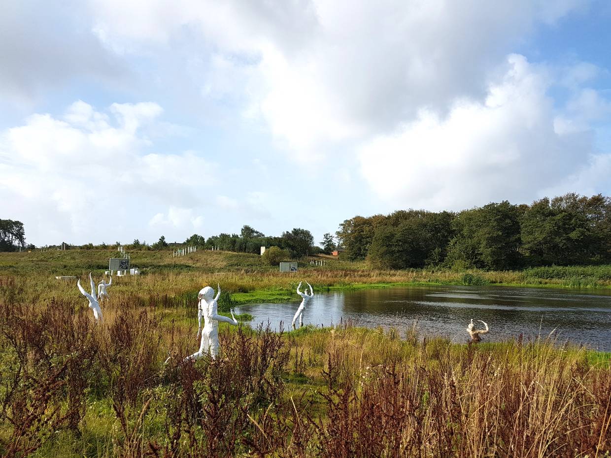 Weiße Figuren an einem kleinen Teich