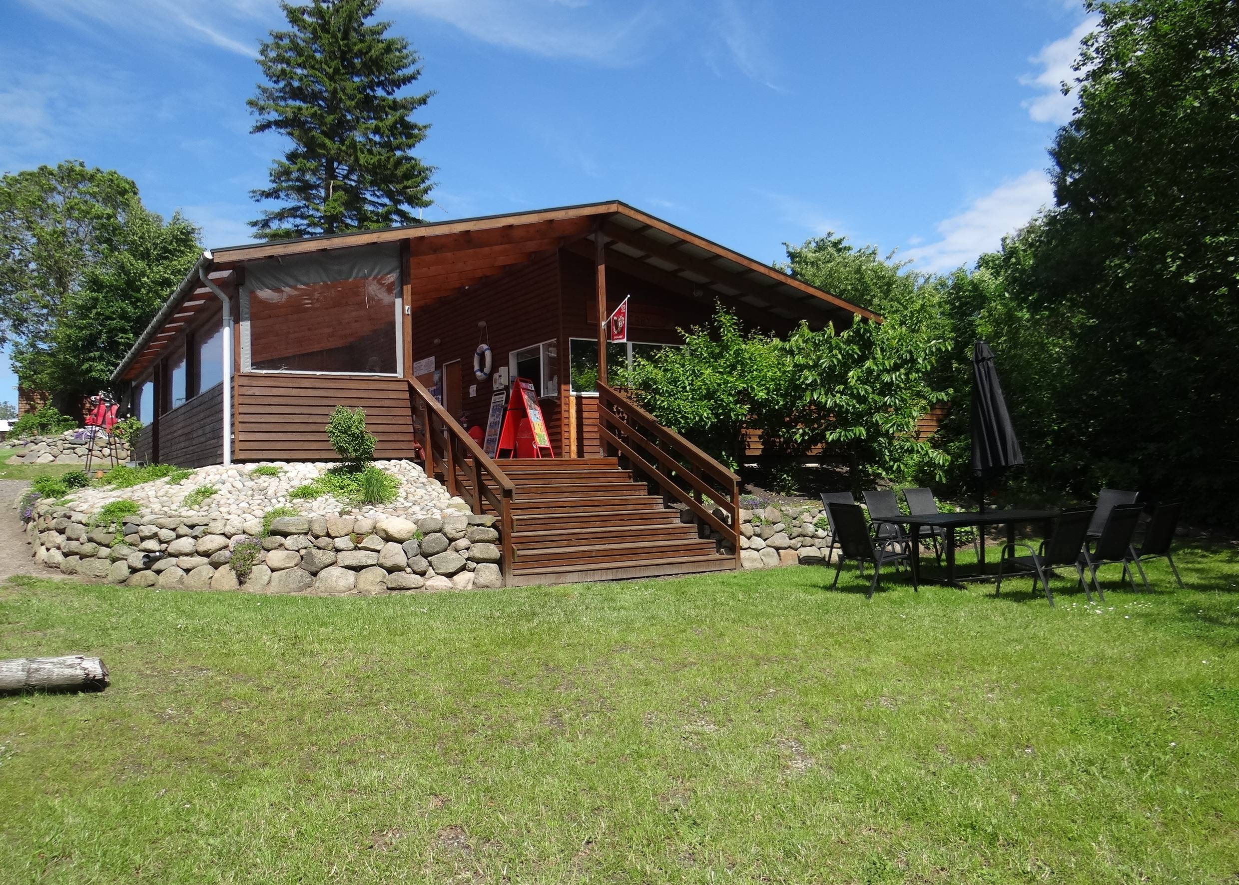 Holzhütte mit einer höher gelegenen Terrasse am Kanuverleih