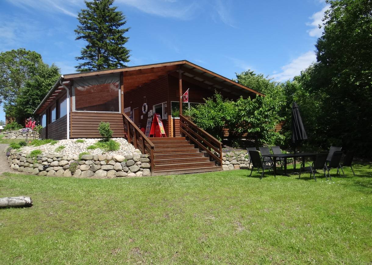 Holzhütte mit einer höher gelegenen Terrasse am Kanuverleih